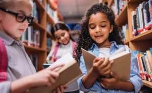 Children reading books in a library.