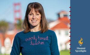 Female wearing a sweatshirt that reads "overly honest teacher" smiling at the camera with an overlay of text "alumni spotlight"