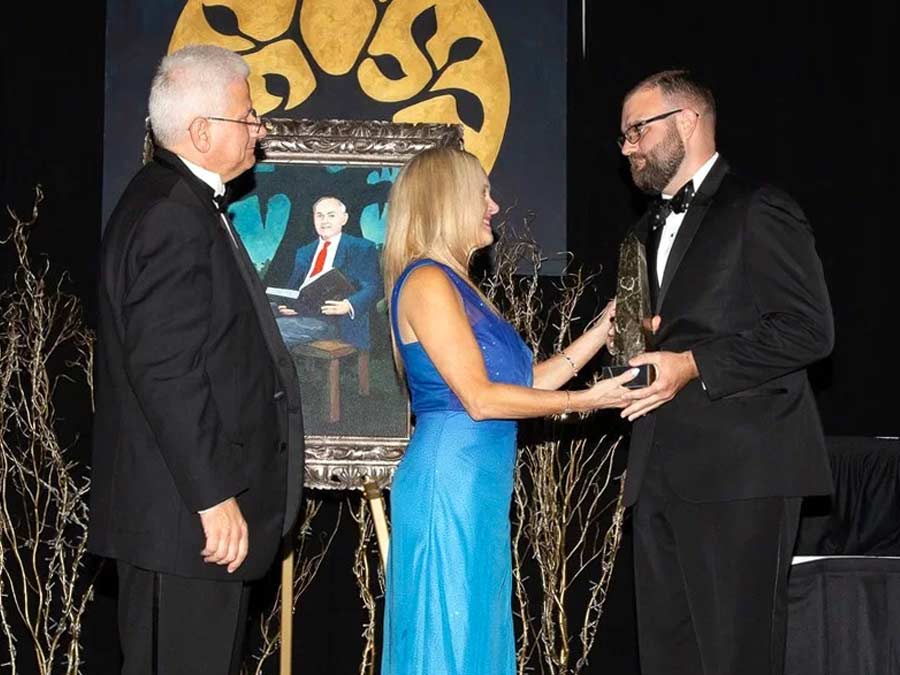 Male and Female wearing formal attire accepting an award.