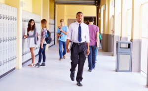 School administrator walking the halls with students in the background