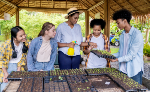 Teacher working in a garden with students during summer