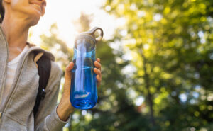 Female walking outside holding a water bottle